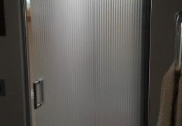 Porta in vetro satinato a righe con perimetro bisellato trasparente